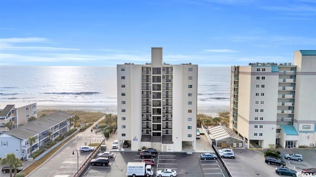 view of property with uncovered parking and a water view