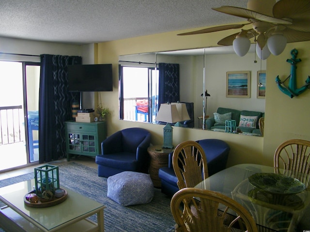 living area featuring a textured ceiling and a ceiling fan