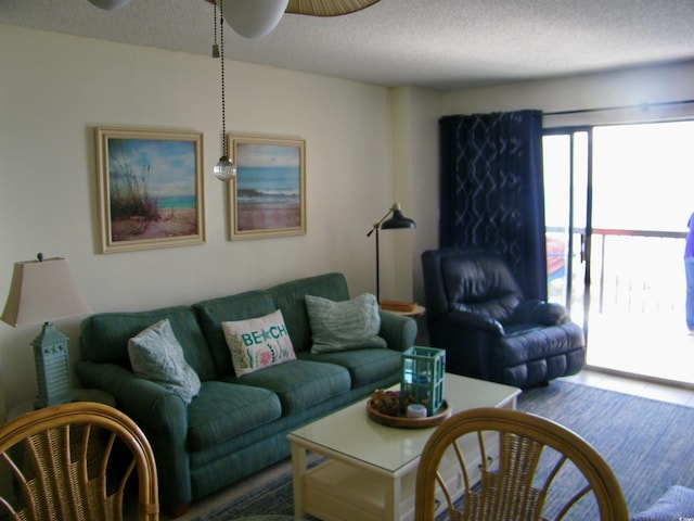 living room featuring a ceiling fan and a textured ceiling