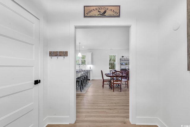 hallway with light wood finished floors and baseboards