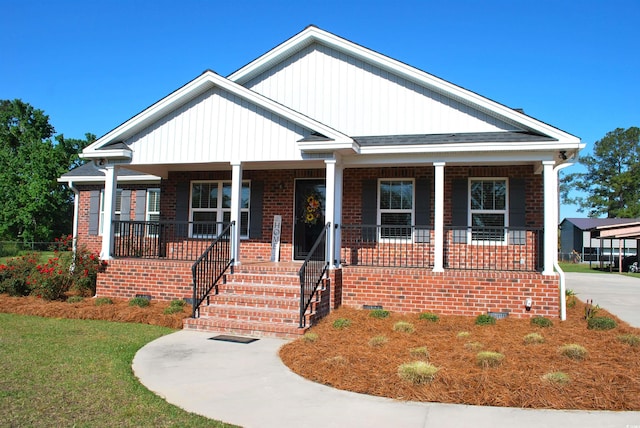 view of front of home with a porch and brick siding