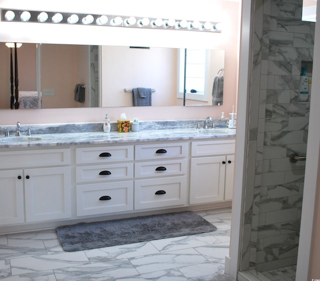 bathroom featuring marble finish floor, double vanity, and a sink