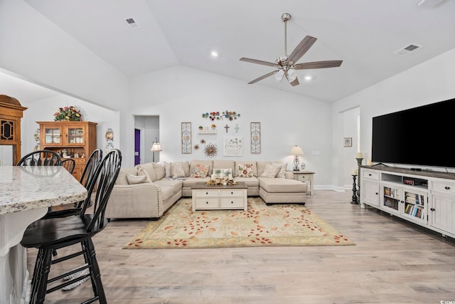 living room featuring light hardwood / wood-style flooring, high vaulted ceiling, and ceiling fan