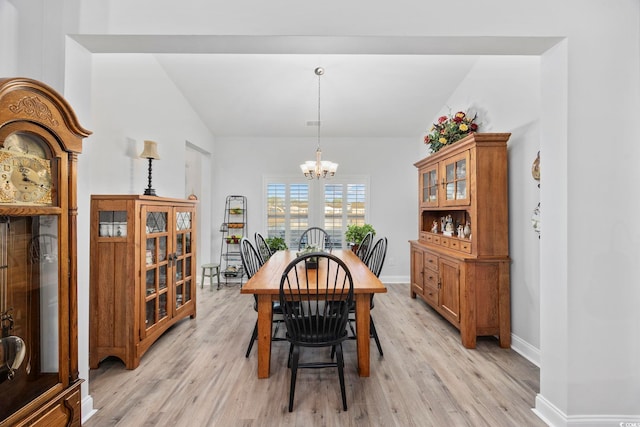 dining area with light hardwood / wood-style flooring and a chandelier