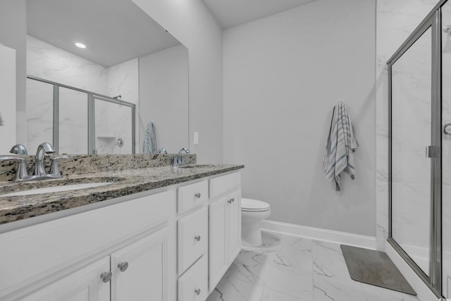 bathroom with vanity, toilet, and a shower with door