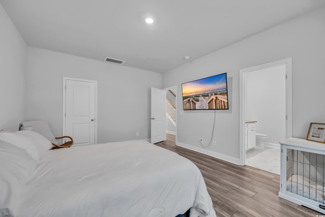 bedroom featuring wood-type flooring and ensuite bath