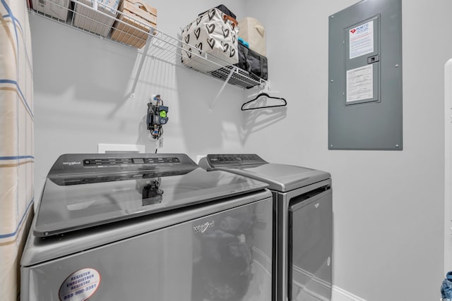 clothes washing area featuring electric panel and washer and clothes dryer