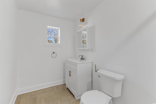 bathroom featuring toilet, baseboards, and vanity