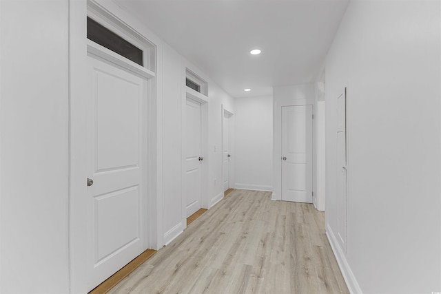 hall with light wood-style floors, baseboards, and recessed lighting