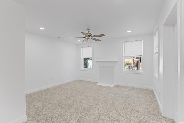 unfurnished living room featuring recessed lighting, light colored carpet, ceiling fan, and baseboards