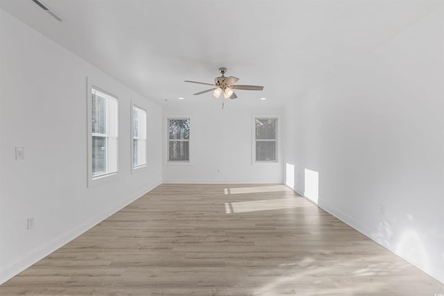 spare room featuring recessed lighting, light wood-type flooring, a wealth of natural light, and a ceiling fan