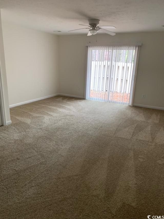 unfurnished room featuring carpet, a ceiling fan, and baseboards