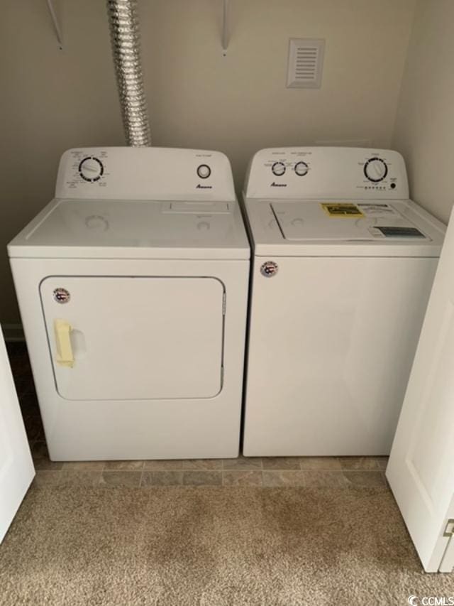 laundry area with laundry area, visible vents, and washer and dryer