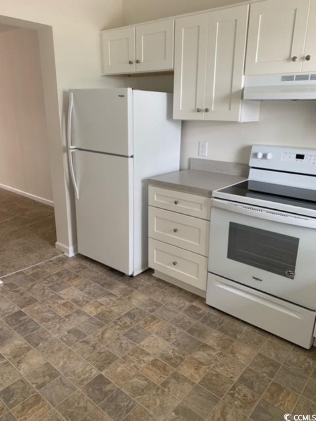 kitchen featuring white appliances, under cabinet range hood, stone finish floor, and white cabinets