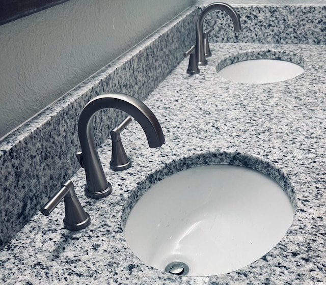 interior details with a textured wall and a sink