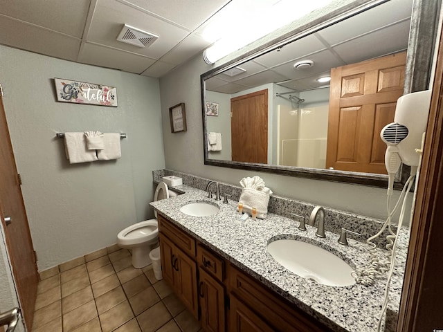 bathroom with a paneled ceiling, tile patterned flooring, visible vents, and a sink