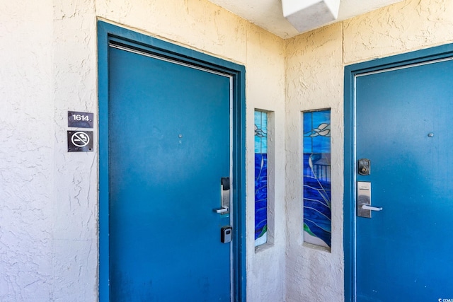 property entrance with stucco siding