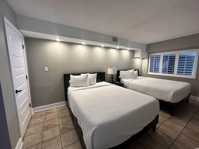 4800 S Ocean Blvd Unit 1514, North Myrtle Beach, SC 29582 - bedroom featuring baseboards, a textured ceiling, and tile patterned flooring