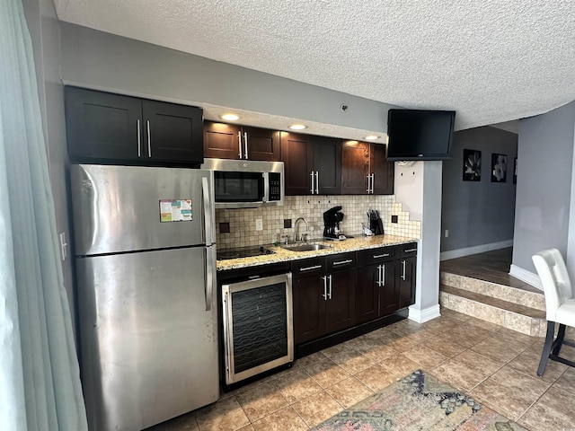 4800 S Ocean Blvd Unit 1514, North Myrtle Beach, SC 29582 - kitchen with stainless steel appliances, beverage cooler, a sink, decorative backsplash, and a textured ceiling
