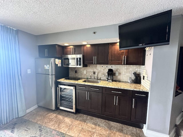 4800 S Ocean Blvd Unit 1514, North Myrtle Beach, SC 29582 - kitchen with appliances with stainless steel finishes, beverage cooler, a sink, backsplash, and a textured ceiling