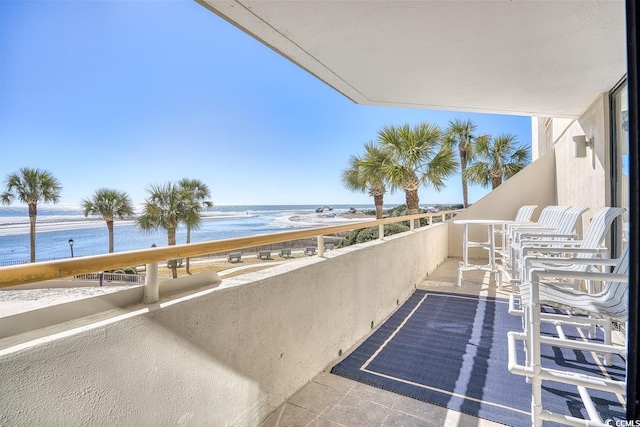 balcony featuring a water view and a view of the beach