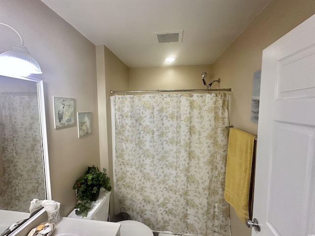 bathroom with vanity, curtained shower, and toilet