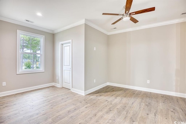 spare room with ceiling fan, light wood finished floors, baseboards, visible vents, and ornamental molding