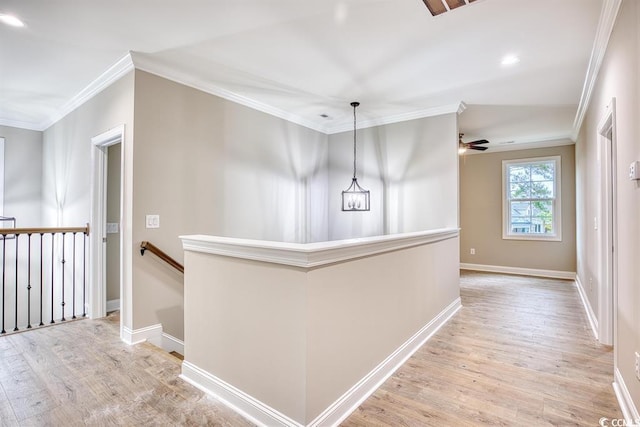 corridor featuring crown molding, baseboards, light wood-type flooring, and an upstairs landing