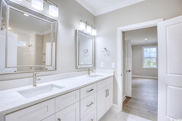 full bathroom with a sink, baseboards, crown molding, and double vanity