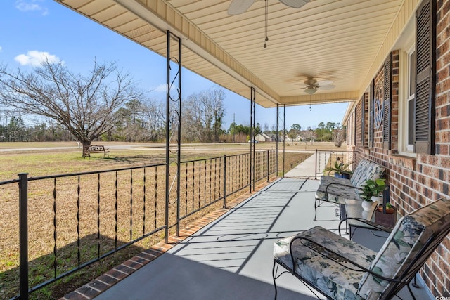 view of patio / terrace featuring ceiling fan, a rural view, and covered porch