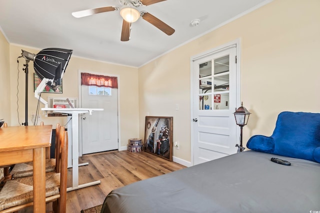 bedroom with light wood-type flooring, crown molding, and ceiling fan