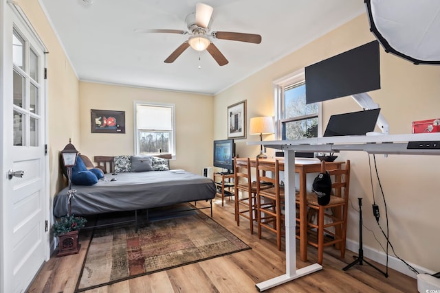 bedroom featuring multiple windows, hardwood / wood-style flooring, and crown molding