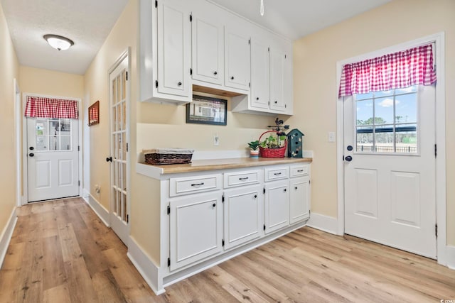 kitchen with light hardwood / wood-style floors and white cabinets