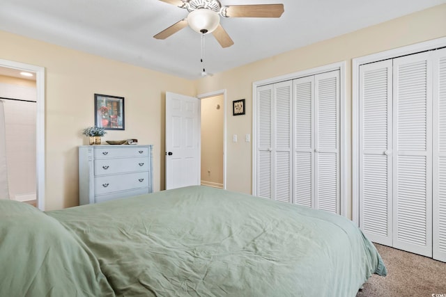 bedroom featuring light colored carpet, ceiling fan, and multiple closets