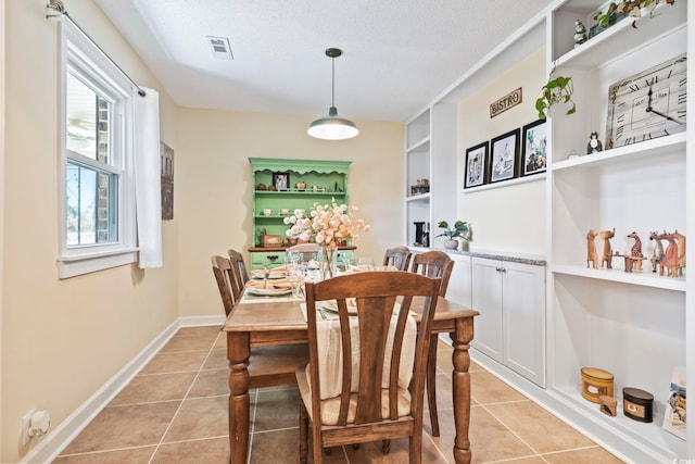 tiled dining room with built in shelves and a textured ceiling