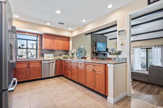 kitchen with sink, stainless steel appliances, tasteful backsplash, and a healthy amount of sunlight