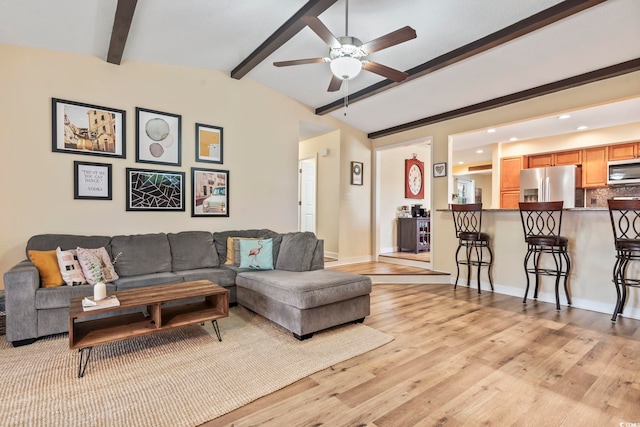 living room featuring ceiling fan, light hardwood / wood-style flooring, and lofted ceiling with beams