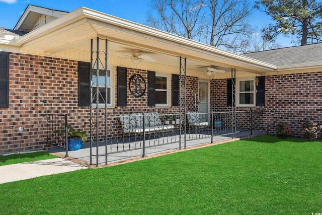 entrance to property with a yard and ceiling fan