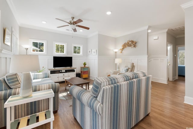 living room featuring ceiling fan, ornamental molding, and light hardwood / wood-style flooring