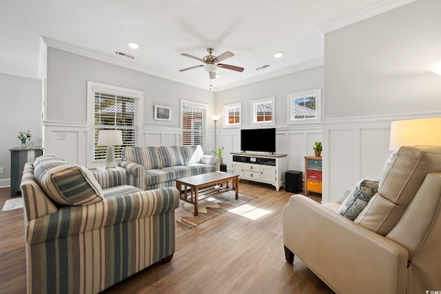 living room with crown molding, wood-type flooring, and ceiling fan