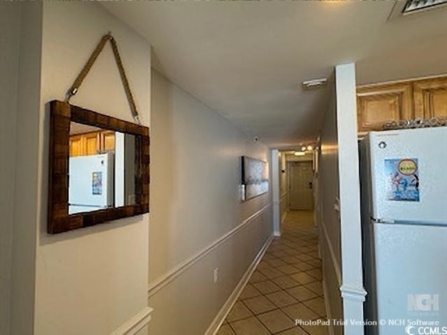 hallway with light tile patterned flooring and baseboards