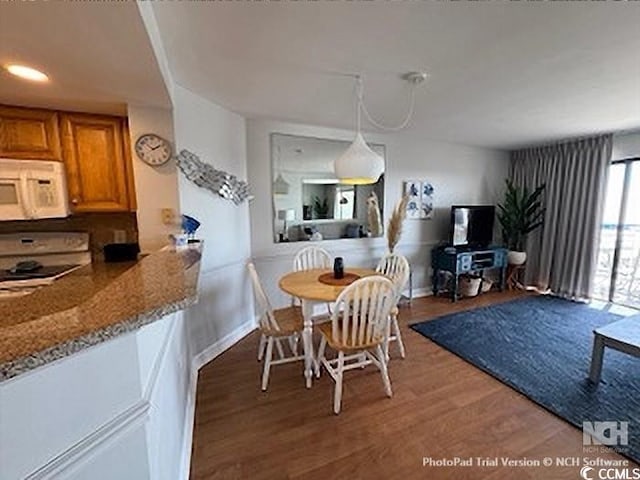 dining area with baseboards and wood finished floors