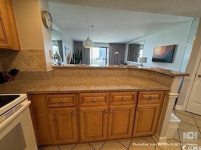 kitchen featuring tasteful backsplash, white electric stove, a peninsula, brown cabinetry, and light tile patterned floors