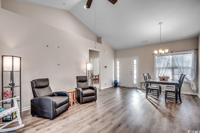 interior space featuring ceiling fan with notable chandelier, high vaulted ceiling, and light hardwood / wood-style floors