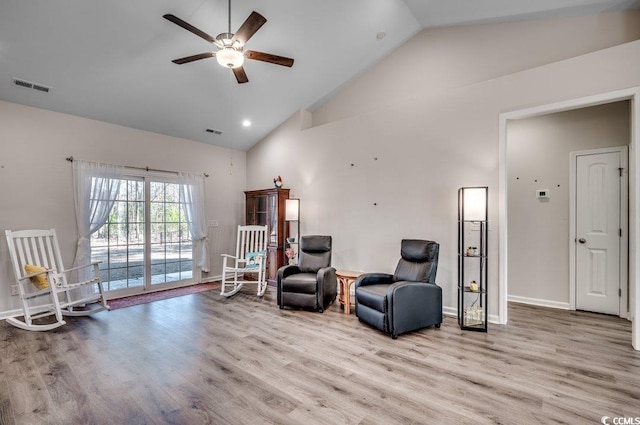 sitting room with high vaulted ceiling, ceiling fan, and light wood-type flooring