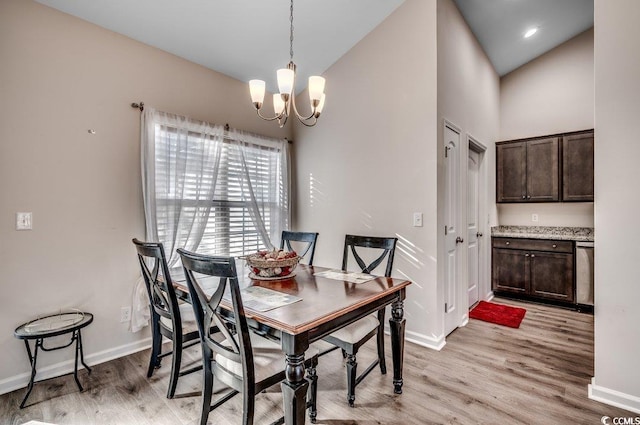 dining area with high vaulted ceiling, a chandelier, and light hardwood / wood-style floors