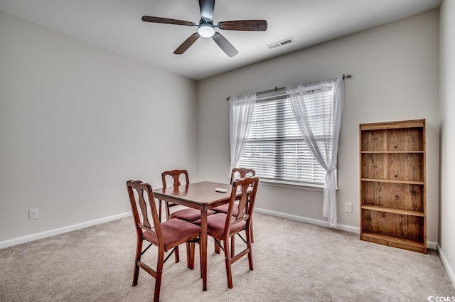 dining room featuring light carpet and ceiling fan