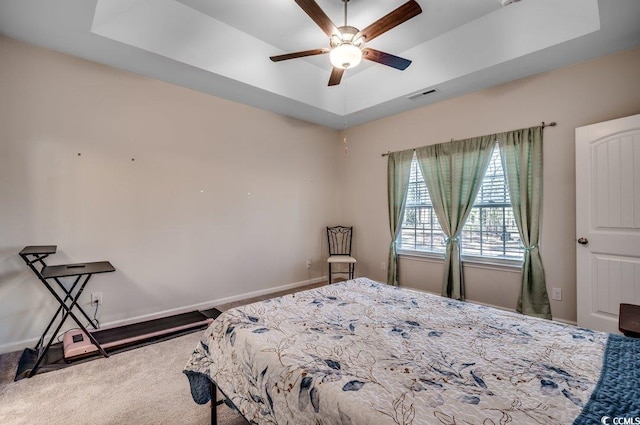 bedroom with ceiling fan, a raised ceiling, and carpet