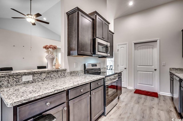 kitchen featuring light stone counters, dark brown cabinetry, stainless steel appliances, and light wood-type flooring