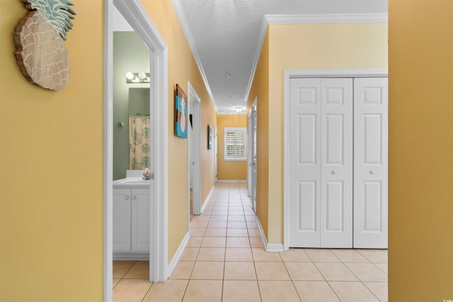 1529 Lanterns Rest Dr Unit 201, Myrtle Beach, SC 29579 - hallway with light tile patterned flooring, ornamental molding, a sink, baseboards, and a textured ceiling